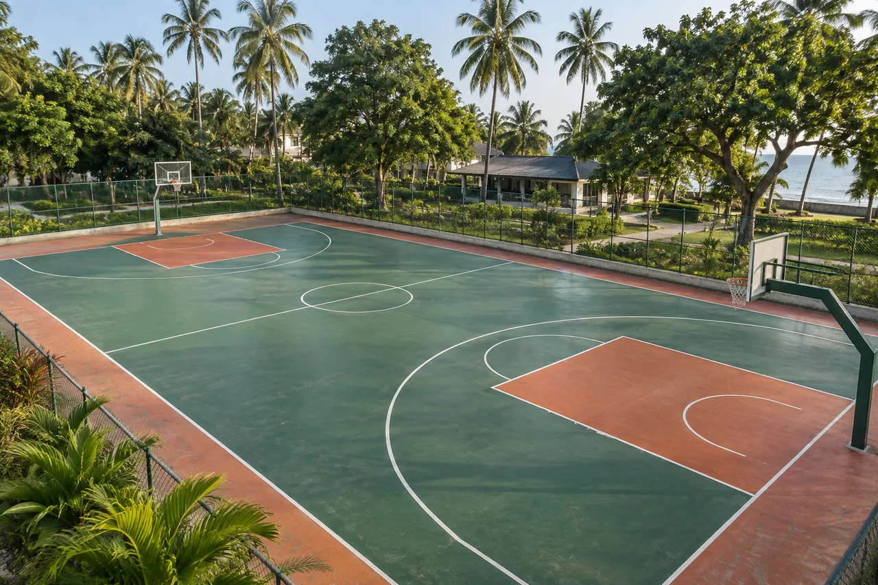 Outdoor basketball court with clear painted lines and palm trees